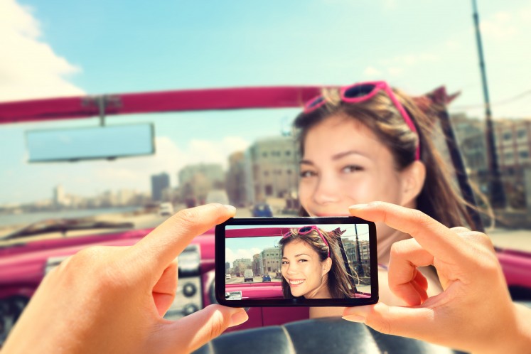 Woman_having_photo_taken_on_phone_in_car