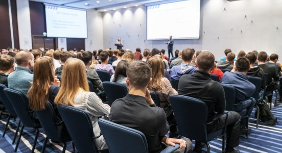 Image of a conference that takes place in a large conference room, workshop for young professionals, training in a large conference room, adult training